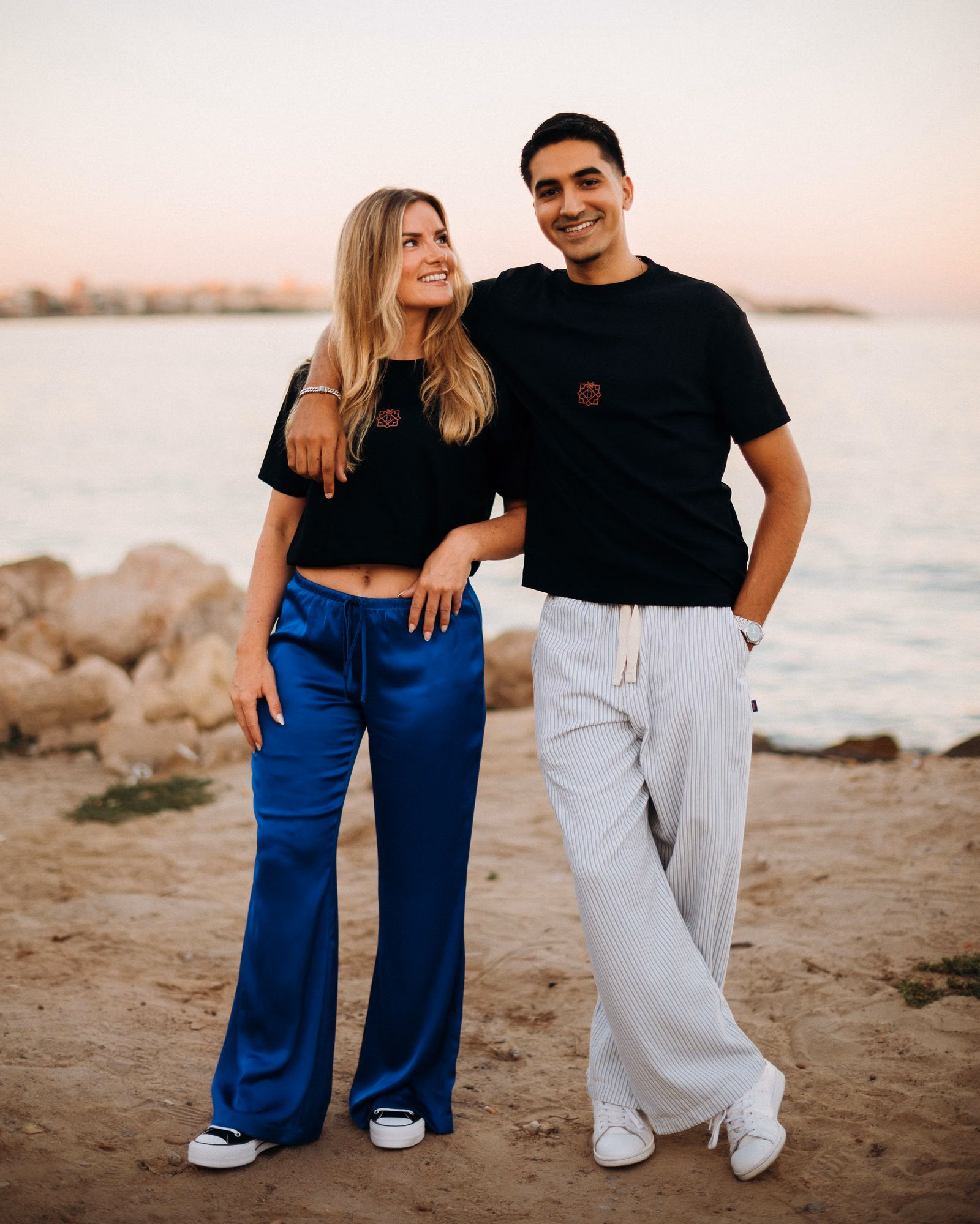 Lisa and Yassine on the beach at sunset, her arm around his shoulder