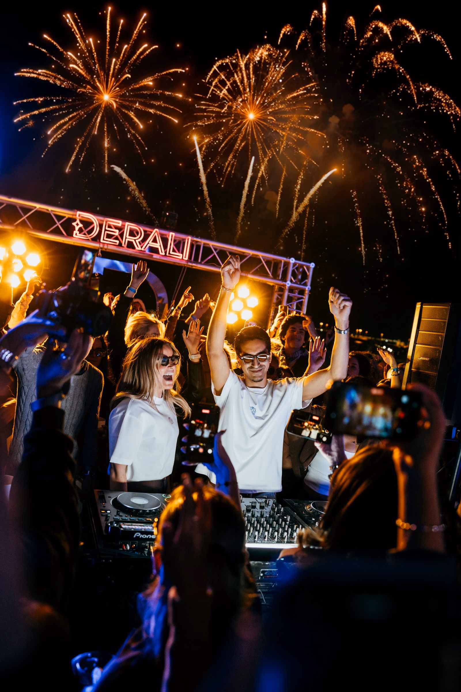 Fireworks over the Derali truss, Lisa and Yassine at the booth with their arms raised