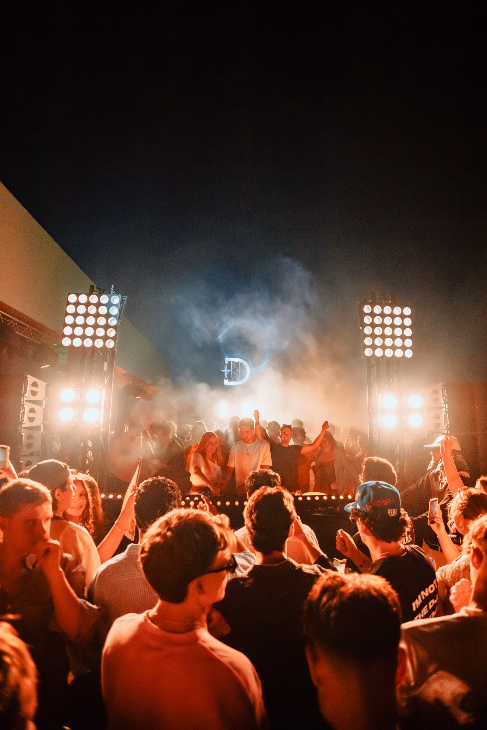Two blinder walls and smoke around the Derali monogram, the open-air crowd from behind